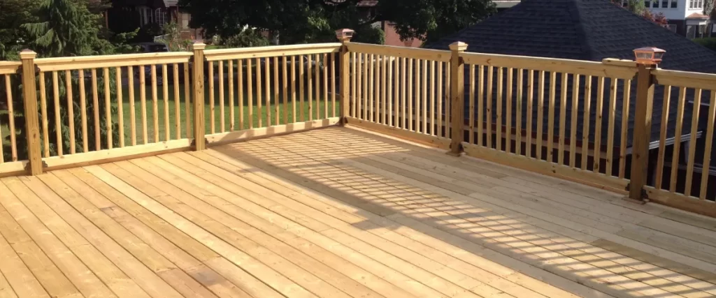 a pressure-treated wood deck with railing