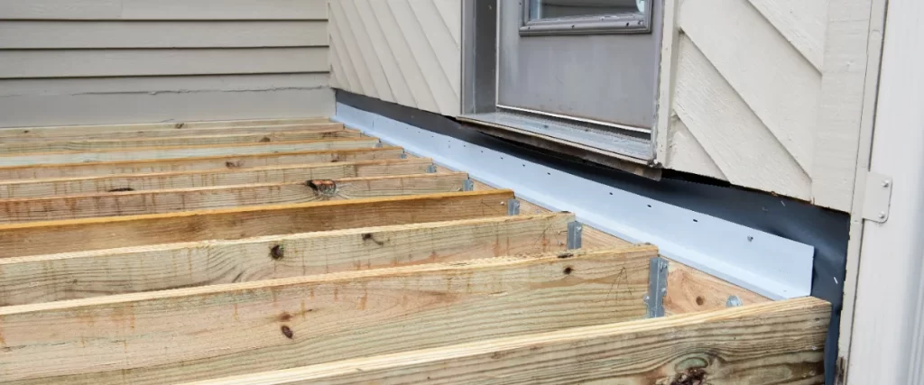 deck ledger flashing installed between the house siding and the deck joists